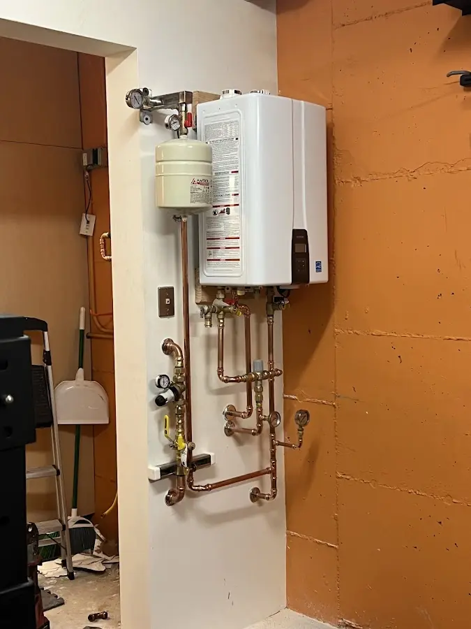 Plumbing technician inspecting water heater connections in Lancaster